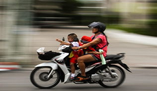 Photo of a woman and her child on a speeding motorbike.